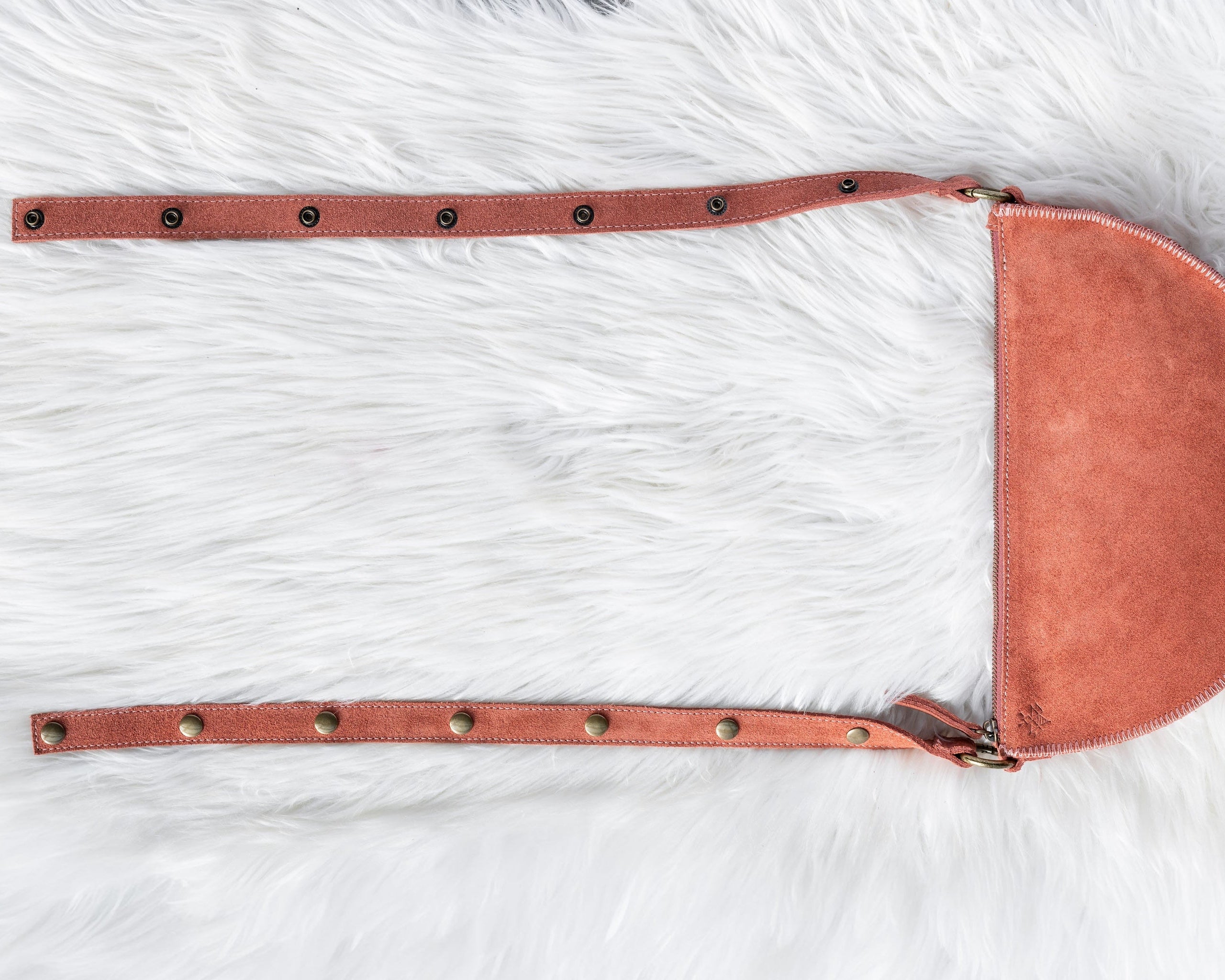 Mauve leather saddle pad on a white fur surface