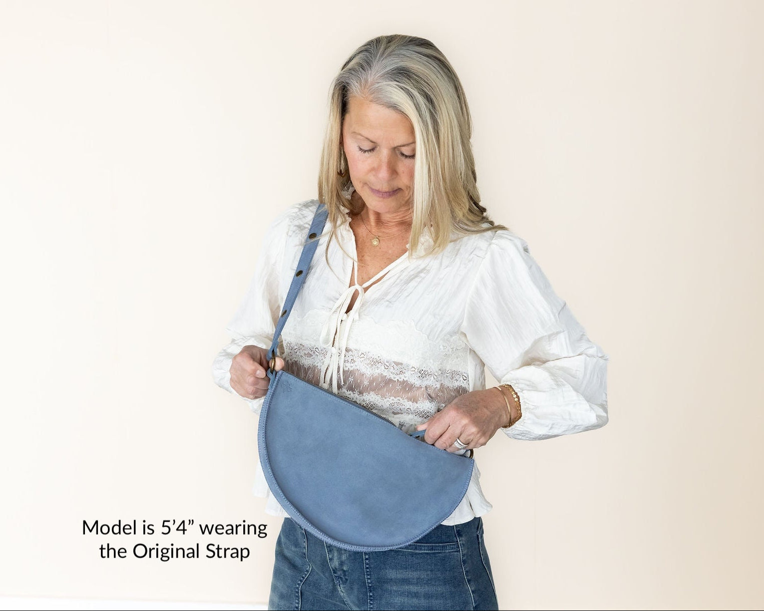 Woman wearing a blue strap over her shoulder against a plain background