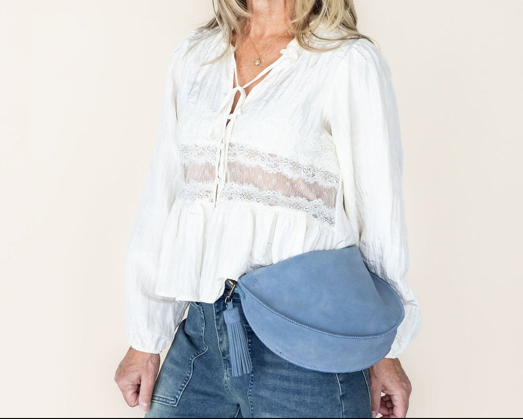 Woman holding a blue bag against a beige background