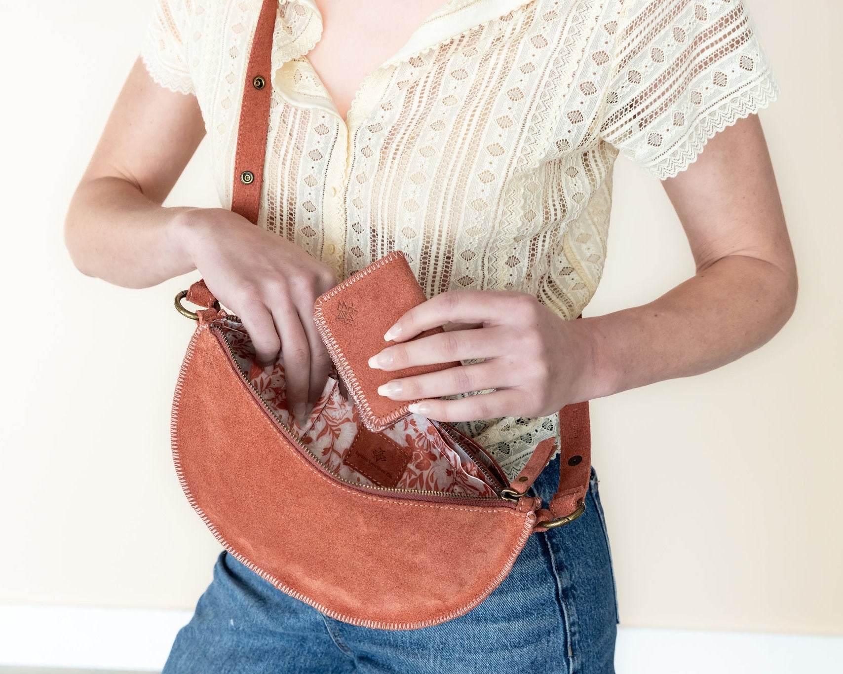 Person holding a brown leather bag with a white background