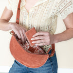 Person holding a brown leather bag with a white background