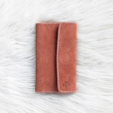 Folded pink blanket on a textured white surface