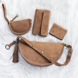 Set of brown leather bags and wallets on a white textured background