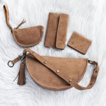 Set of brown leather bags and wallets on a white textured background