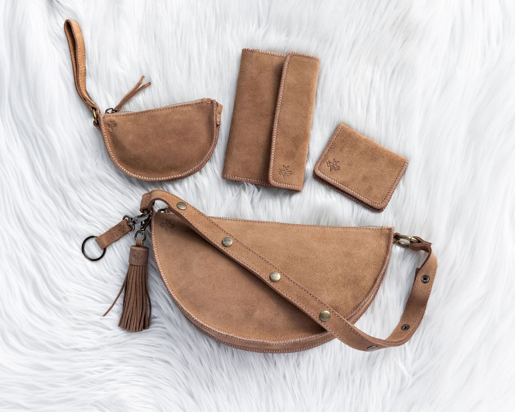 Set of brown leather bags and wallets on a white textured background