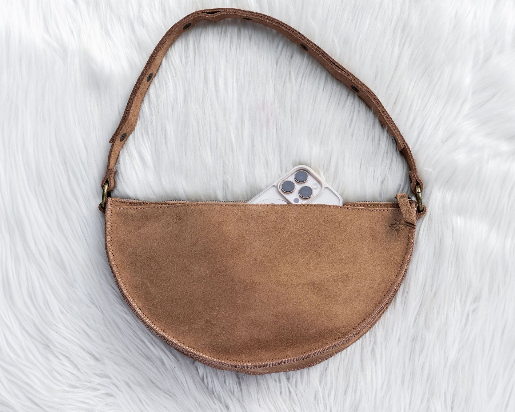 Brown leather bag on a white textured surface