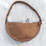 Brown leather bag on a white textured surface