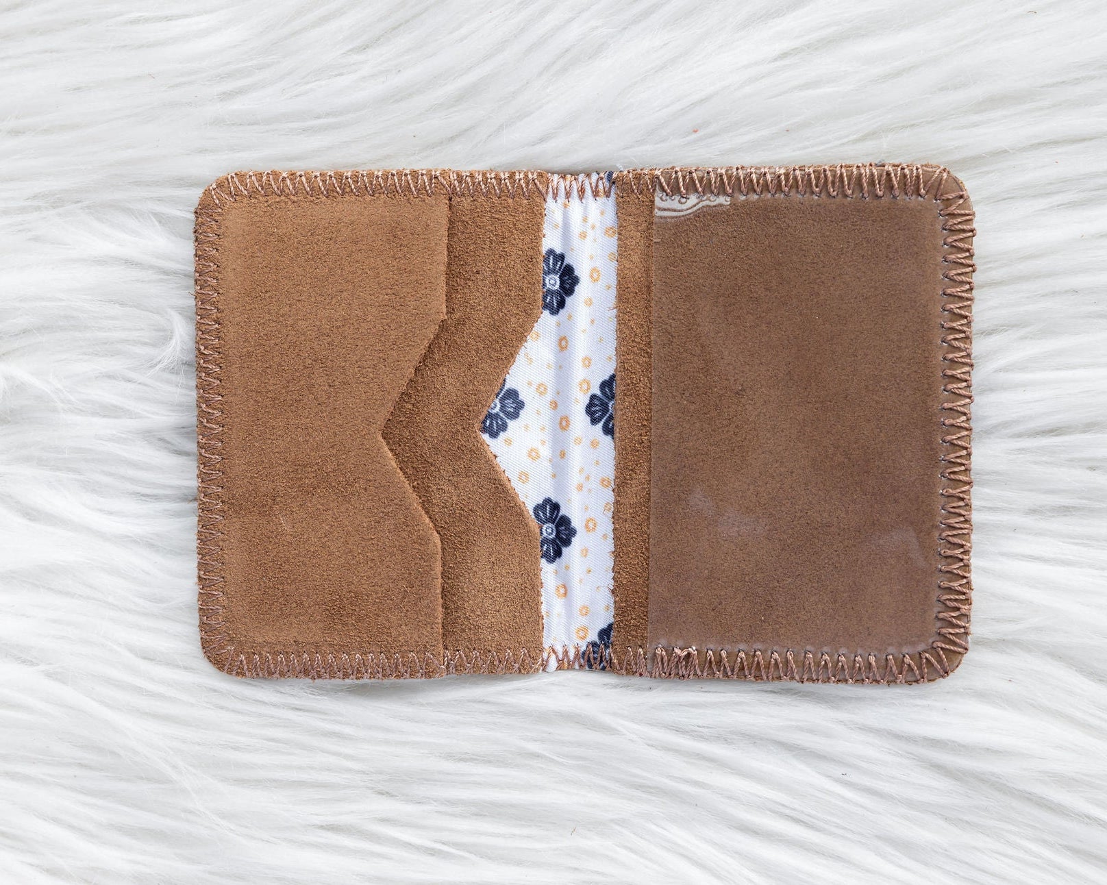 Brown fabric cardholder with floral pattern on a white textured background
