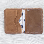 Brown fabric cardholder with floral pattern on a white textured background