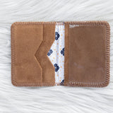 Brown fabric cardholder with floral pattern on a white textured background