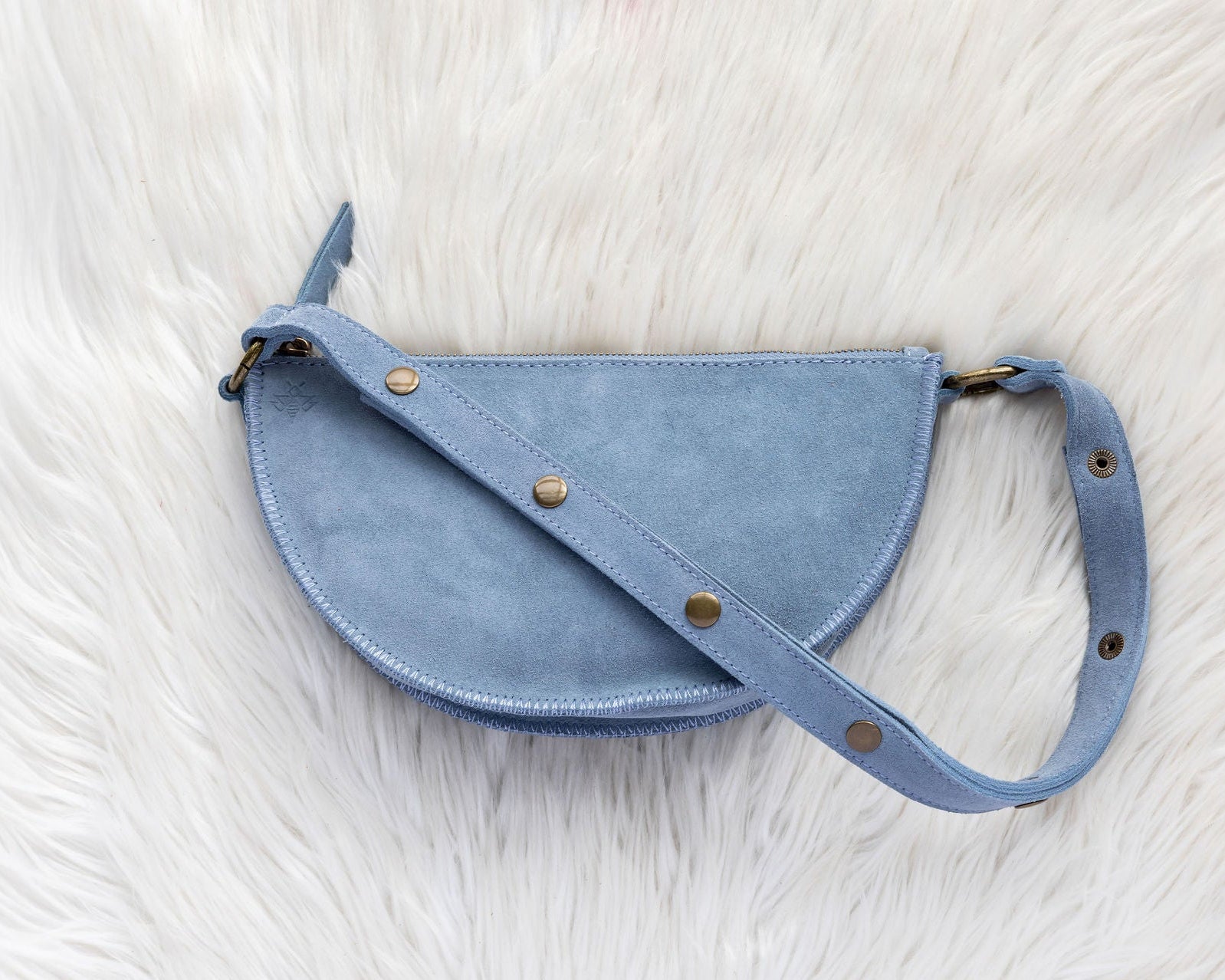 Blue leather bag on a white fur surface