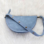 Blue leather bag on a white fur surface