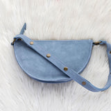 Blue leather bag on a white fur surface