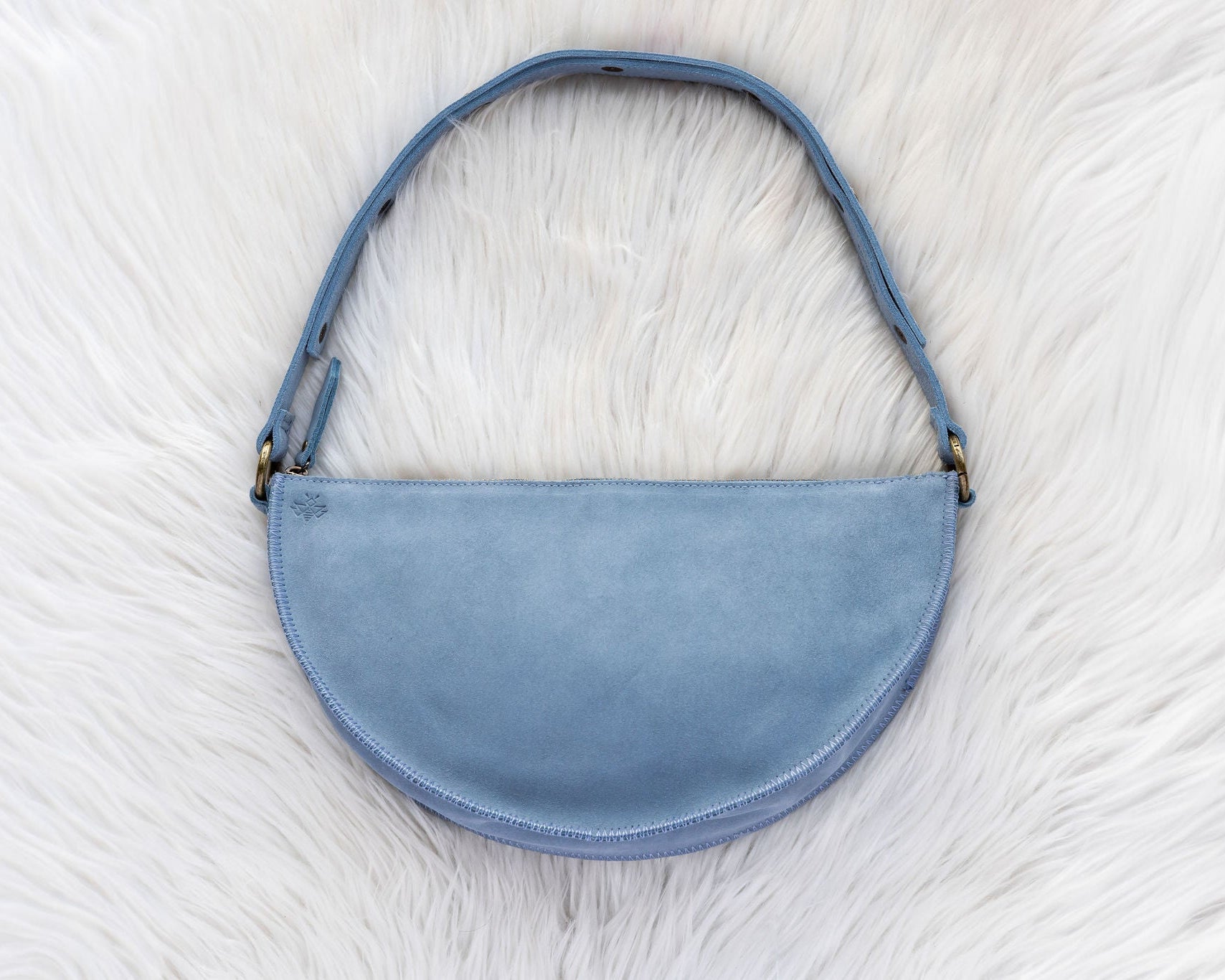 Blue handbag on a white fur surface