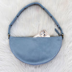 Blue handbag on a white textured surface