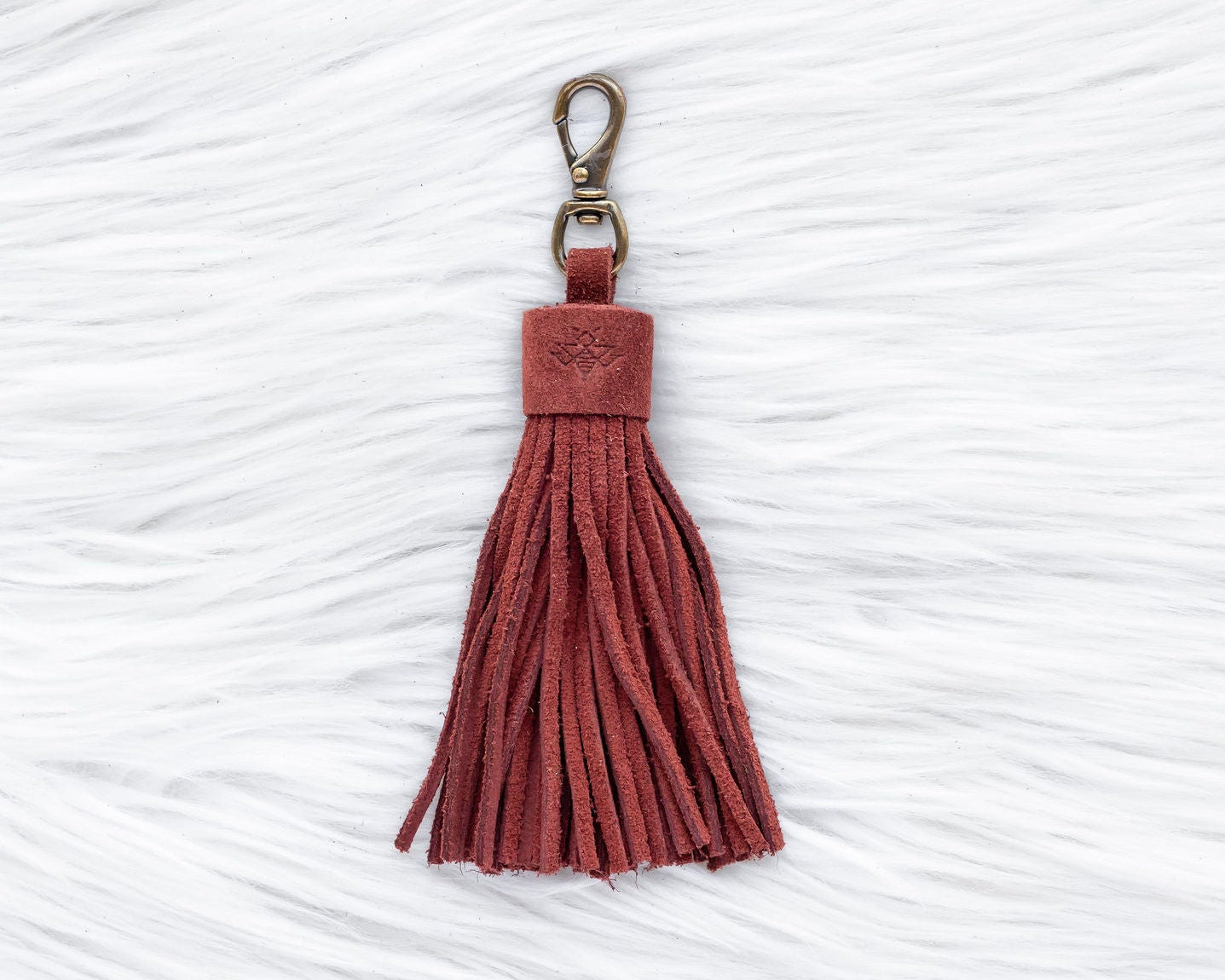 Red tassel keychain on a textured white background