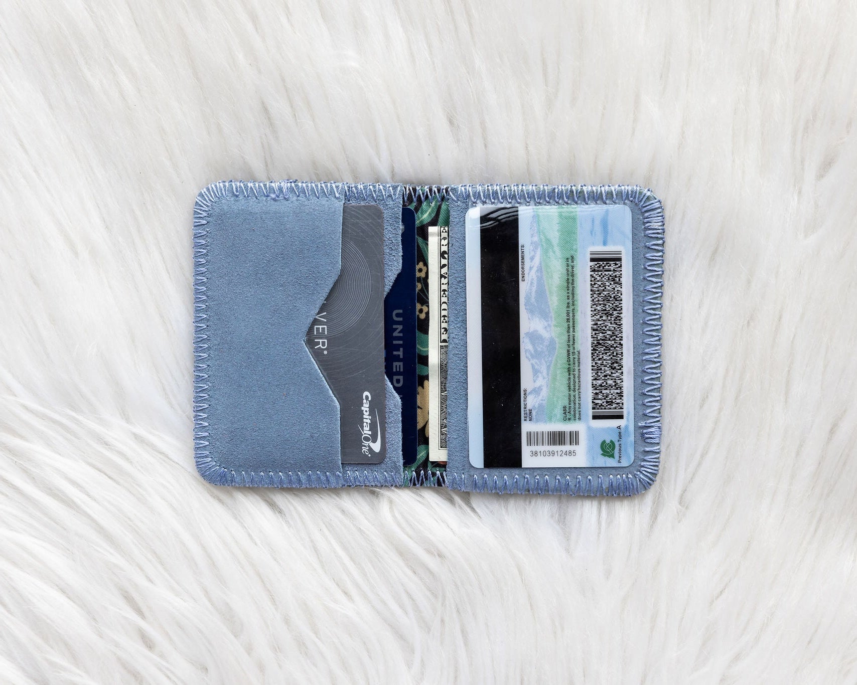 Blue cardholder with cards on a white textured surface