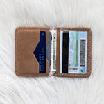 Brown cardholder with cards and money on a white textured surface
