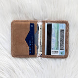 Brown cardholder with cards and money on a white textured surface