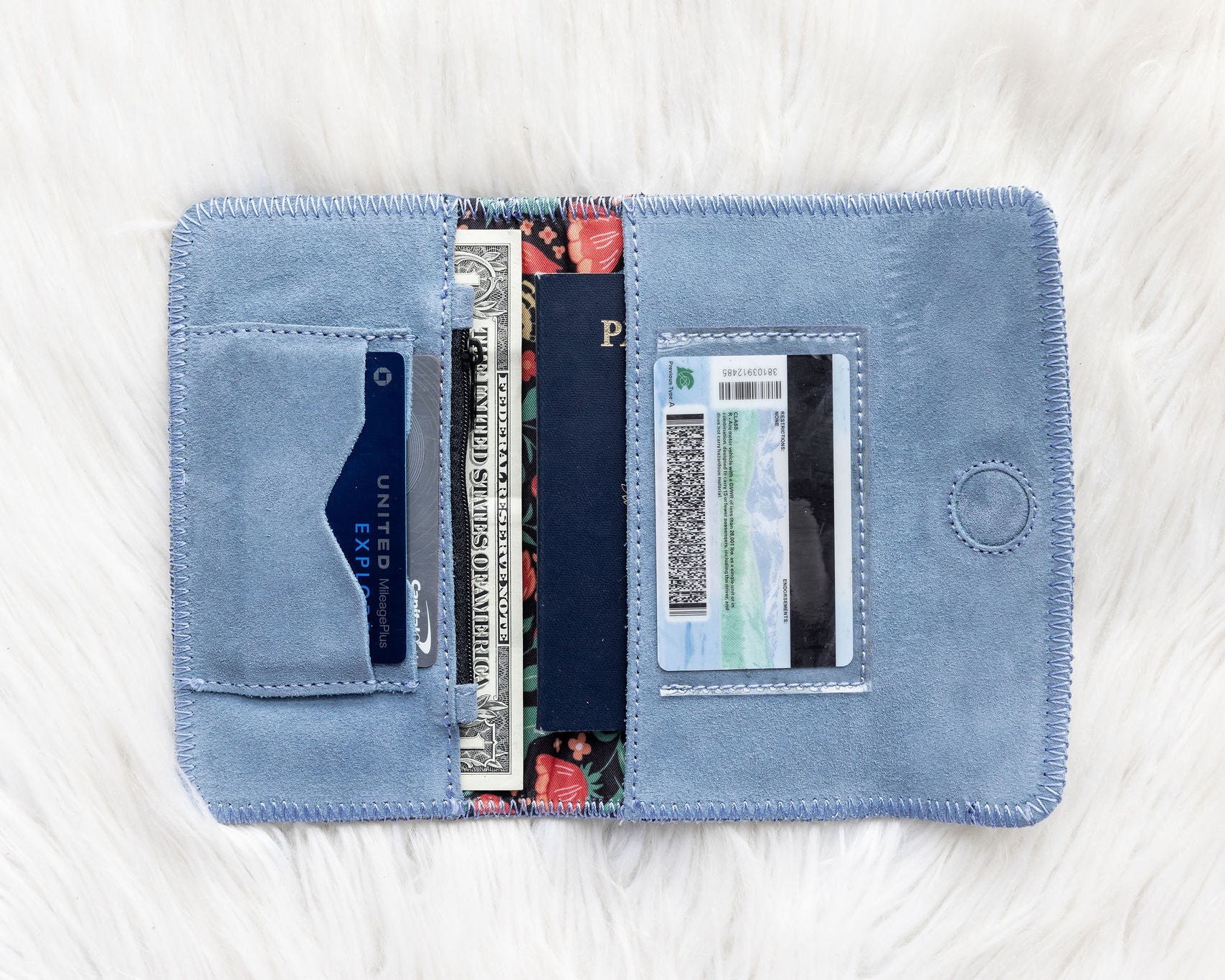 Blue wallet with cards and a passport on a white textured surface