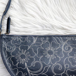 Navy blue bag with floral pattern on a white fur surface