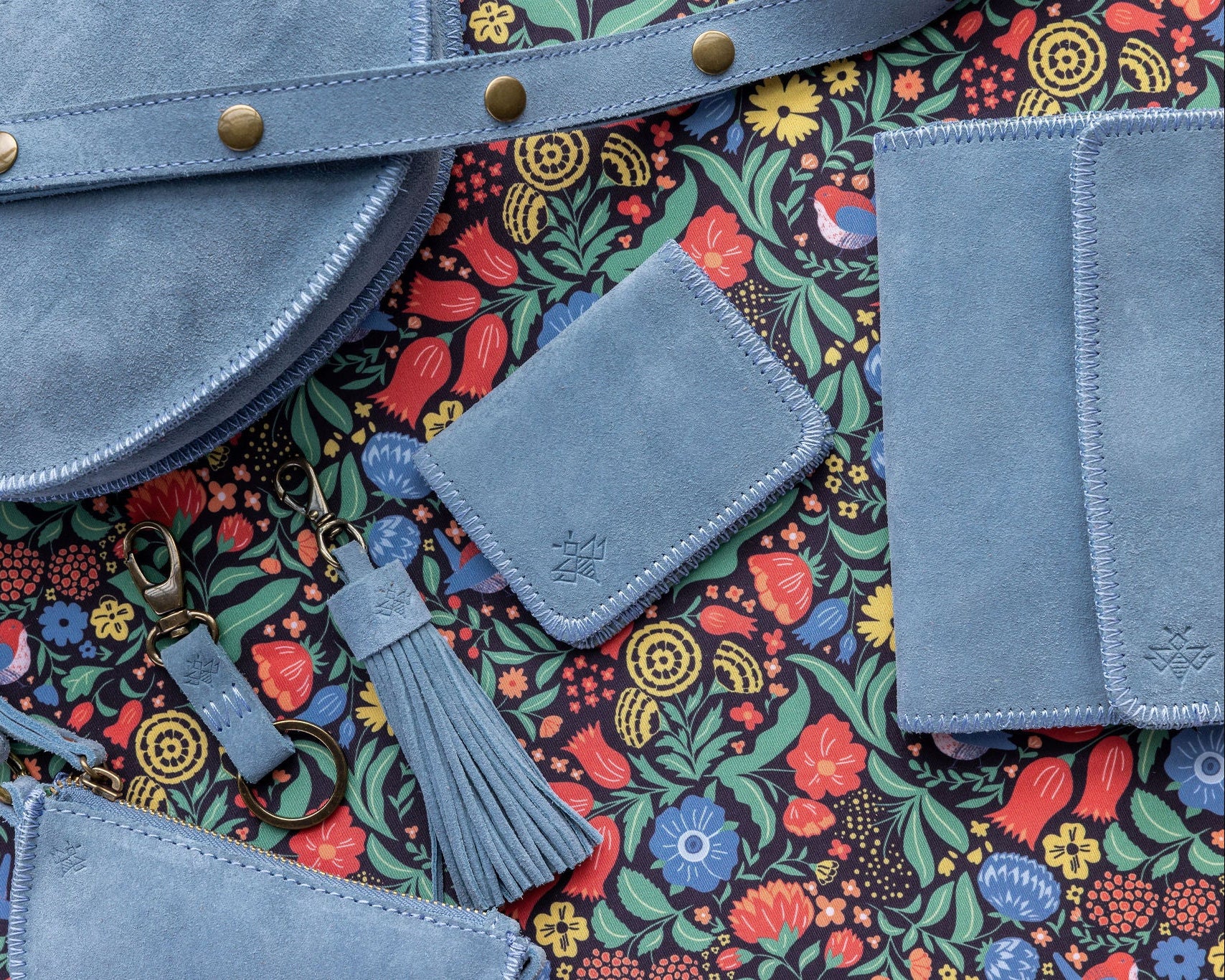 Blue leather bags with a colorful floral pattern background
