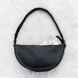 Black leather bag on a white fur surface