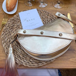 Table setting with wine glasses, bread, and decorative elements on a wooden table.