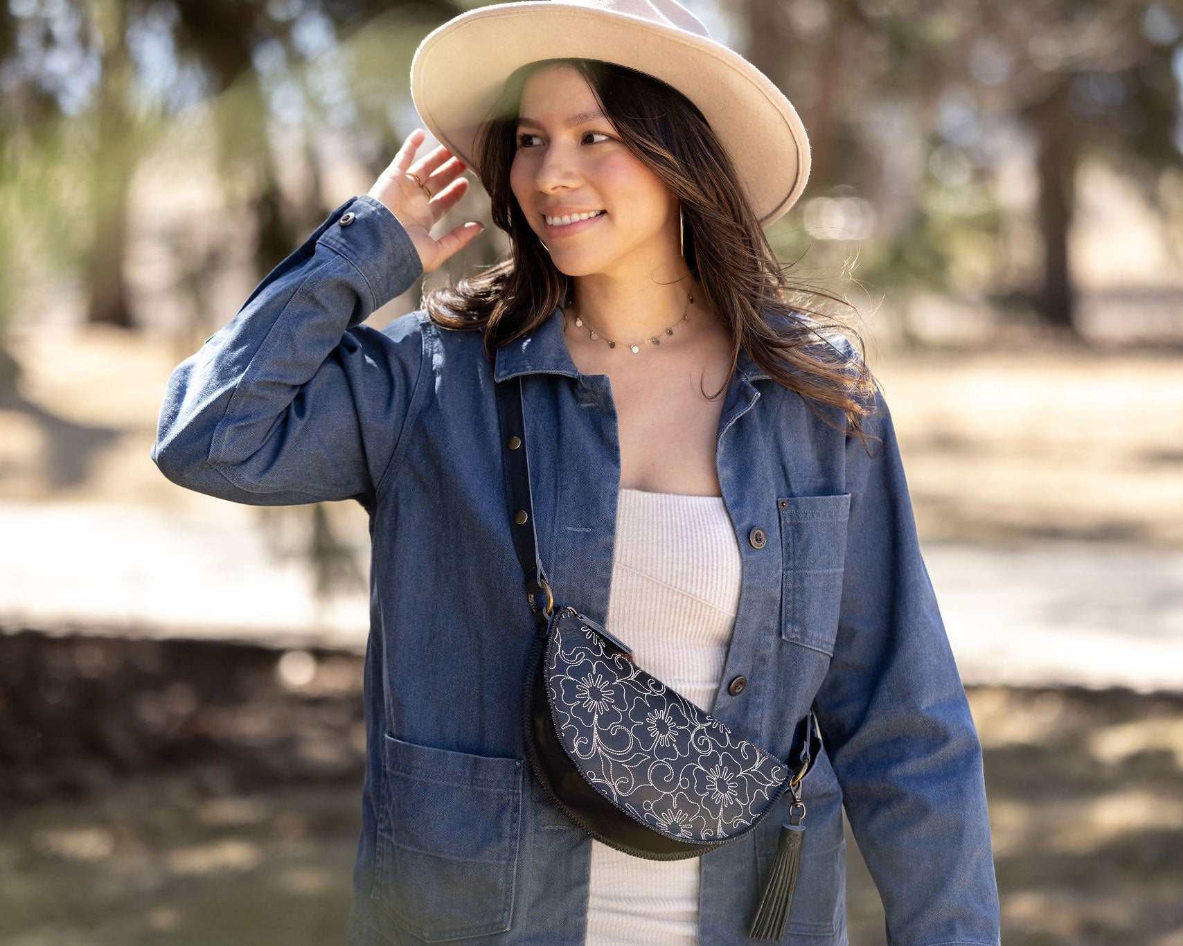 Woman wearing a blue denim jacket and beige hat outdoors
