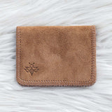 Brown leather cardholder on a white textured background