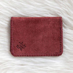 Red leather wallet on a white fur surface