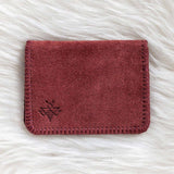 Red leather wallet on a white fur surface