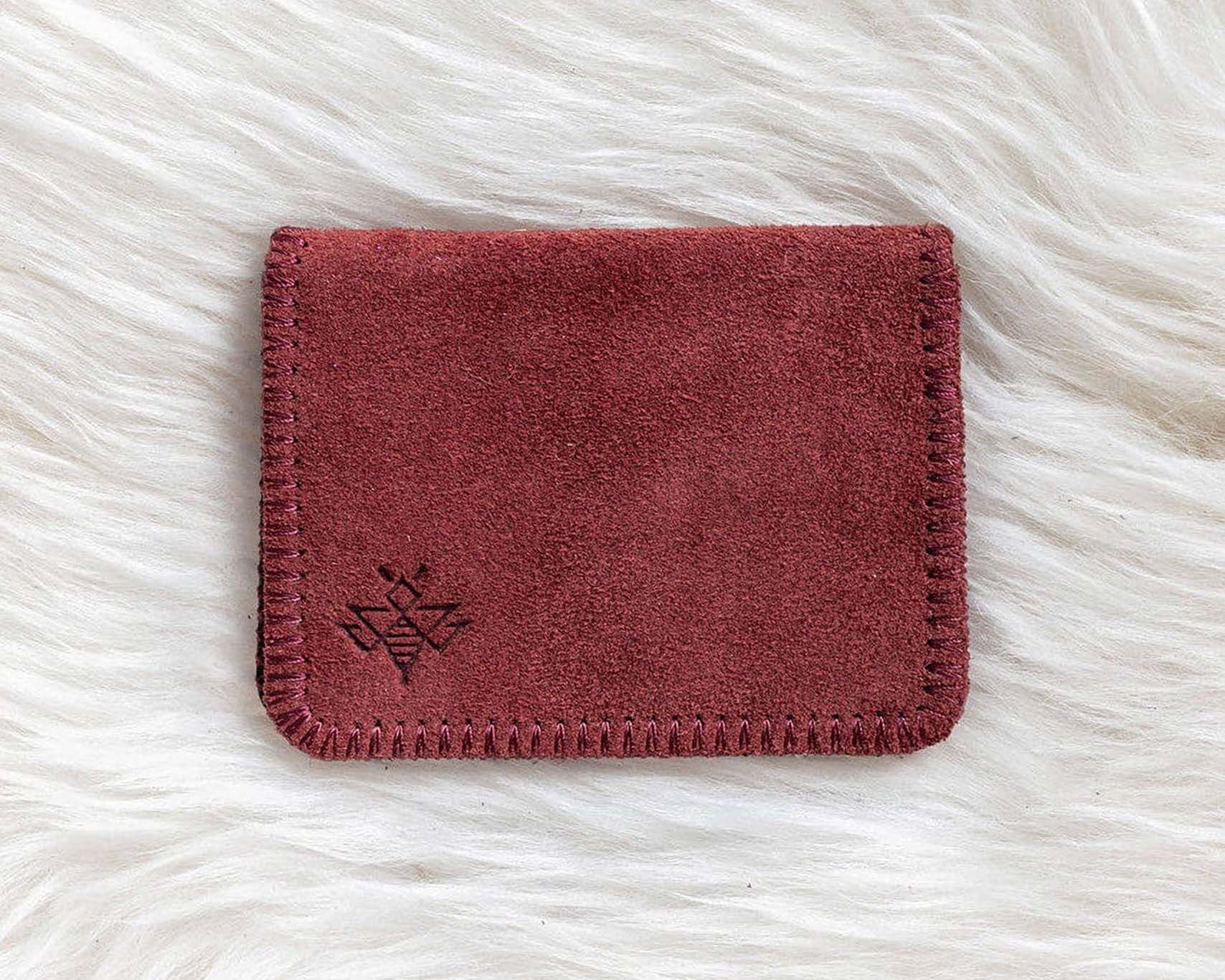 Red leather wallet on a white fur surface
