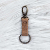 Keychain with brown leather strap on a textured white surface