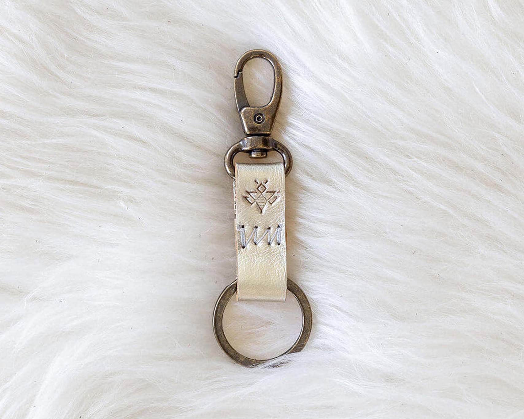 Keychain with engraved text on a white fur surface