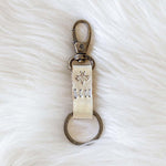 Keychain with engraved text on a white fur surface