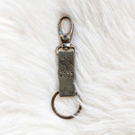 Keychain with a metal clasp on a white textured background