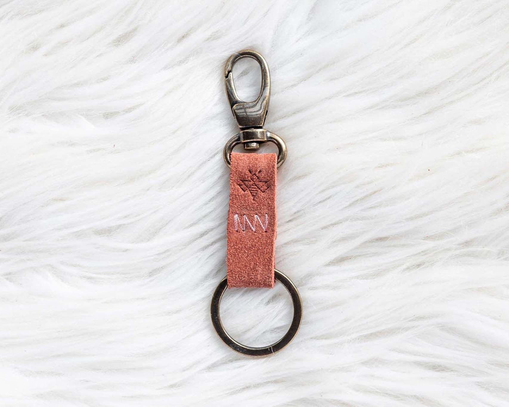 Keychain with pink leather strap on a textured white surface