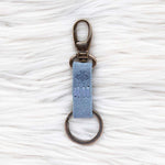 Keychain with a blue tag on a white textured background