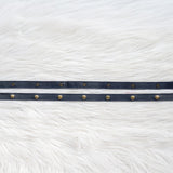 Navy leather straps with gold snaps on a white fur background