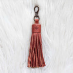 Brown leather tassel keychain on a white textured background