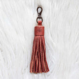 Brown leather tassel keychain on a white textured background