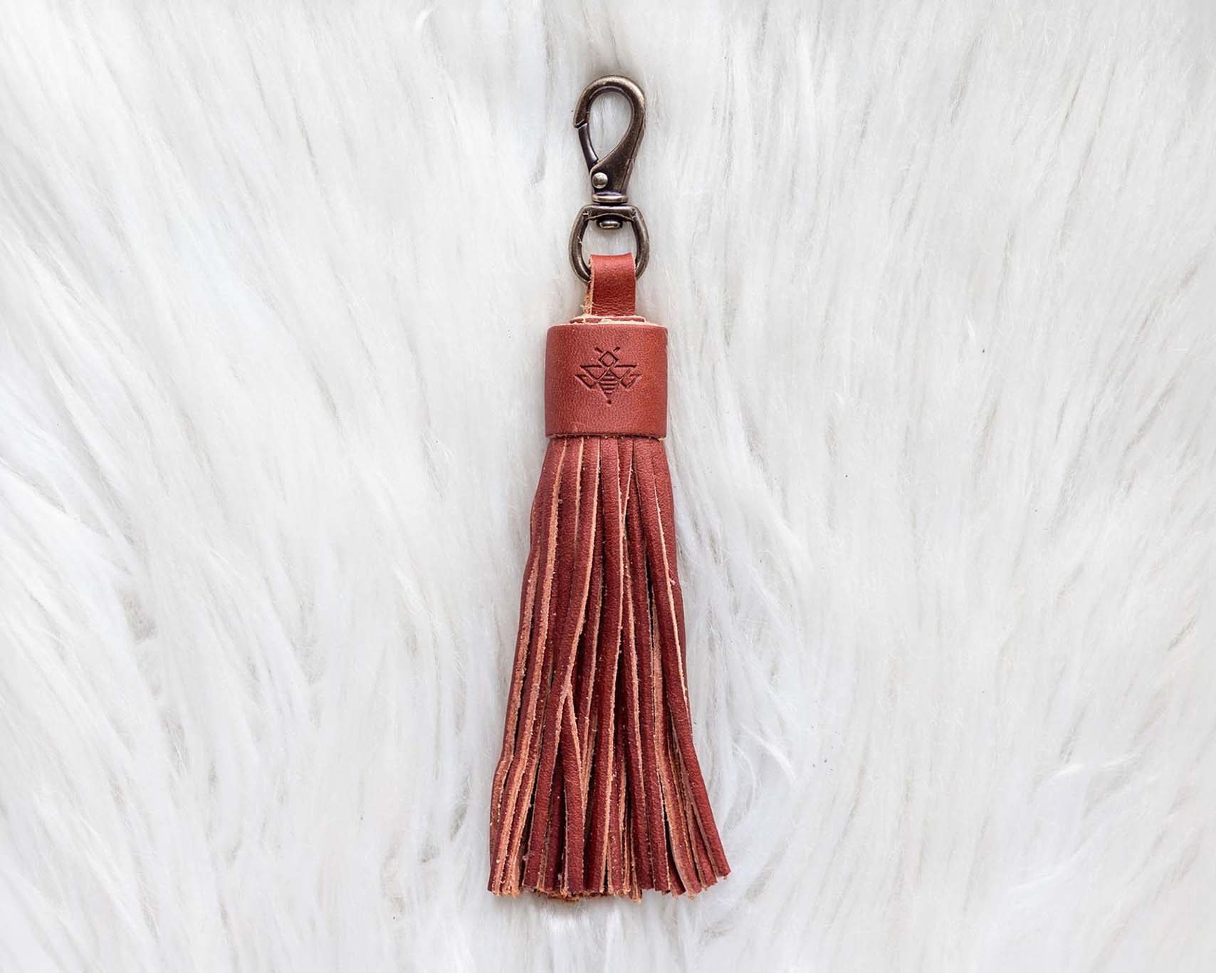 Brown leather tassel keychain on a white textured background