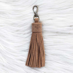 Brown tassel keychain on a textured white background