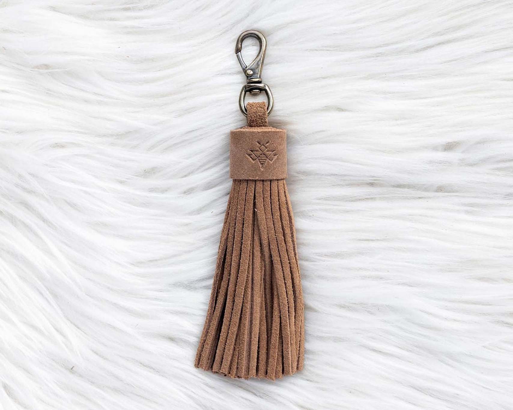 Brown tassel keychain on a textured white background