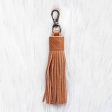Brown leather tassel keychain on a white textured background