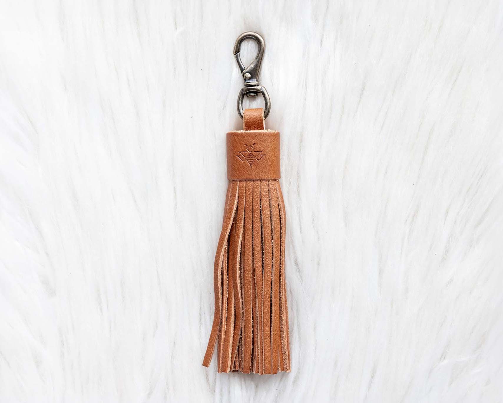 Brown leather tassel keychain on a white textured background