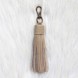 Beige tassel keychain on a white textured background