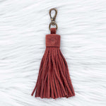 Red tassel keychain on a textured white background