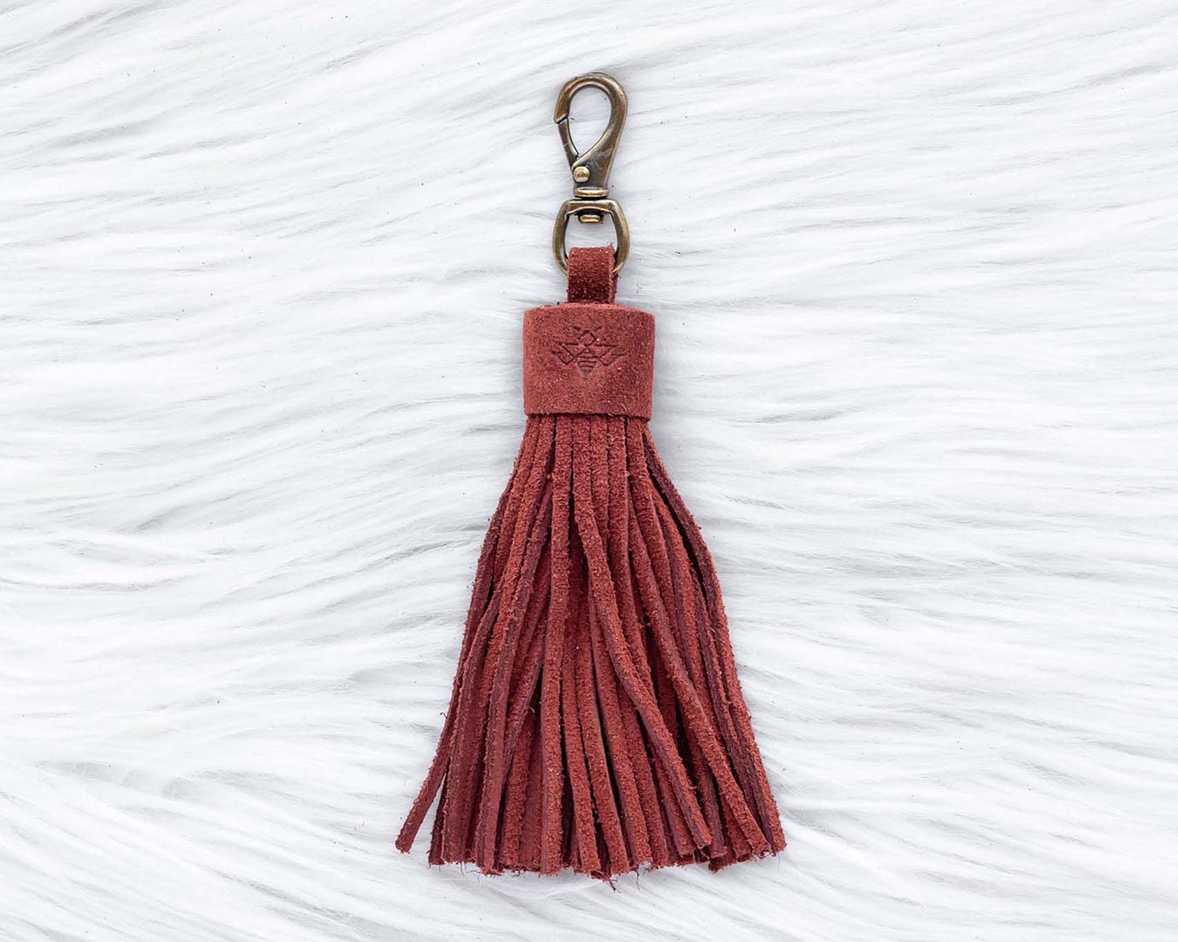 Red tassel keychain on a textured white background